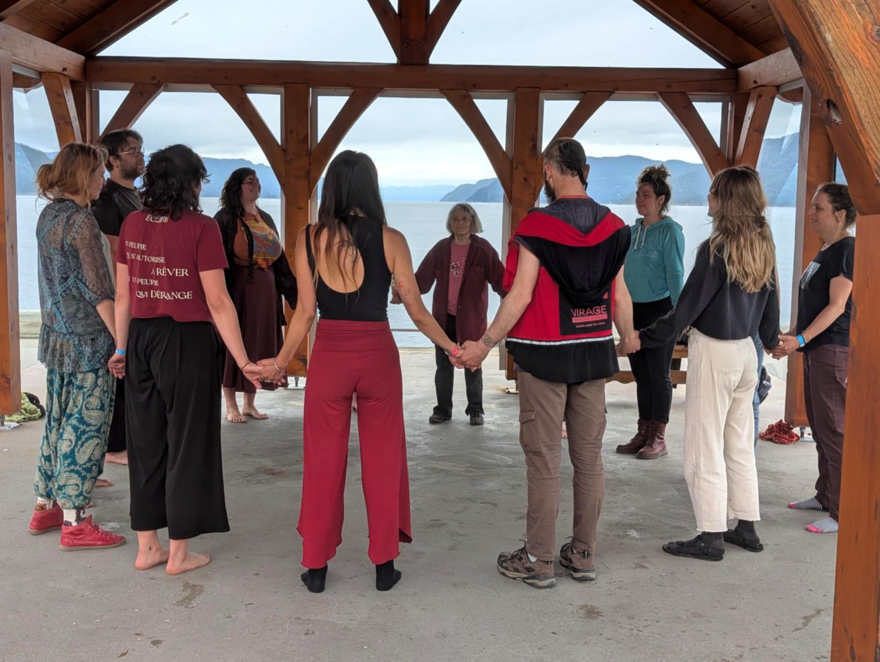 Groupe en cercle sous une structure extérieure en bois pendant une retraite.