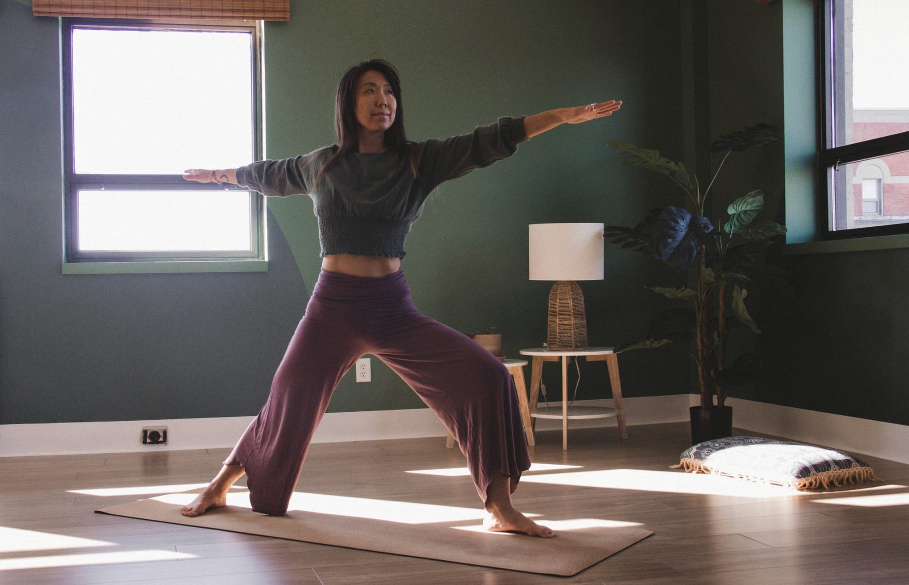 Letitia Rose pratique un mouvement de yoga-danse dans un studio lumineux.