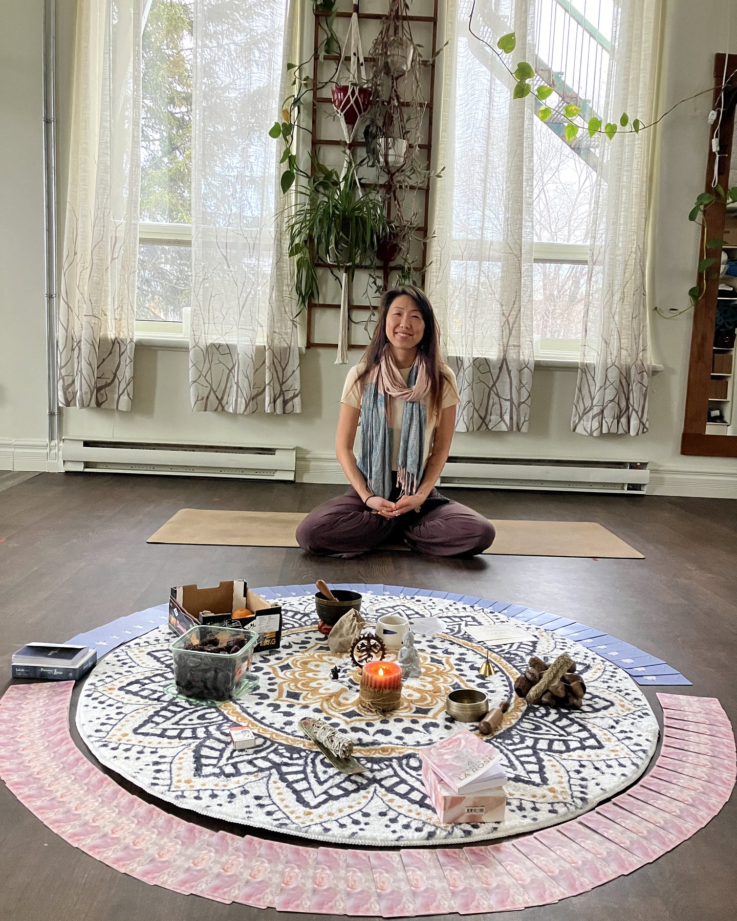 Letitia Rose dans un espace de séance privée lumineux avec tapis, plantes et cercle de pratique.